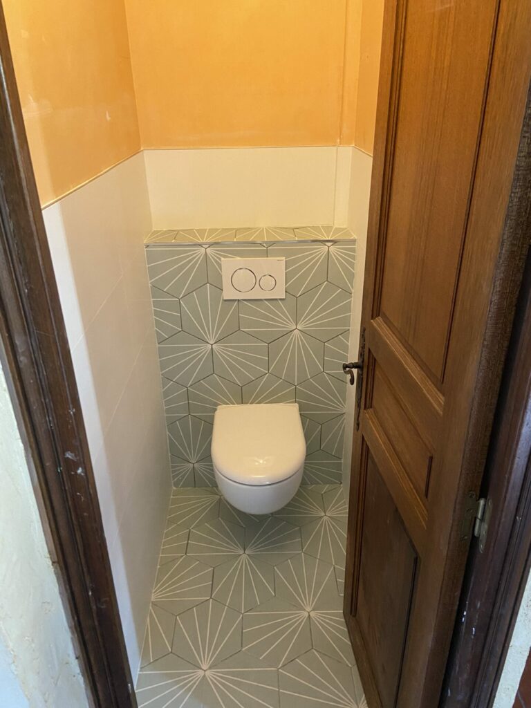 Installation de WC avec carrelage par notre équipe de plombiers experts. Cette image montre un WC suspendu avec un carrelage mural assorti